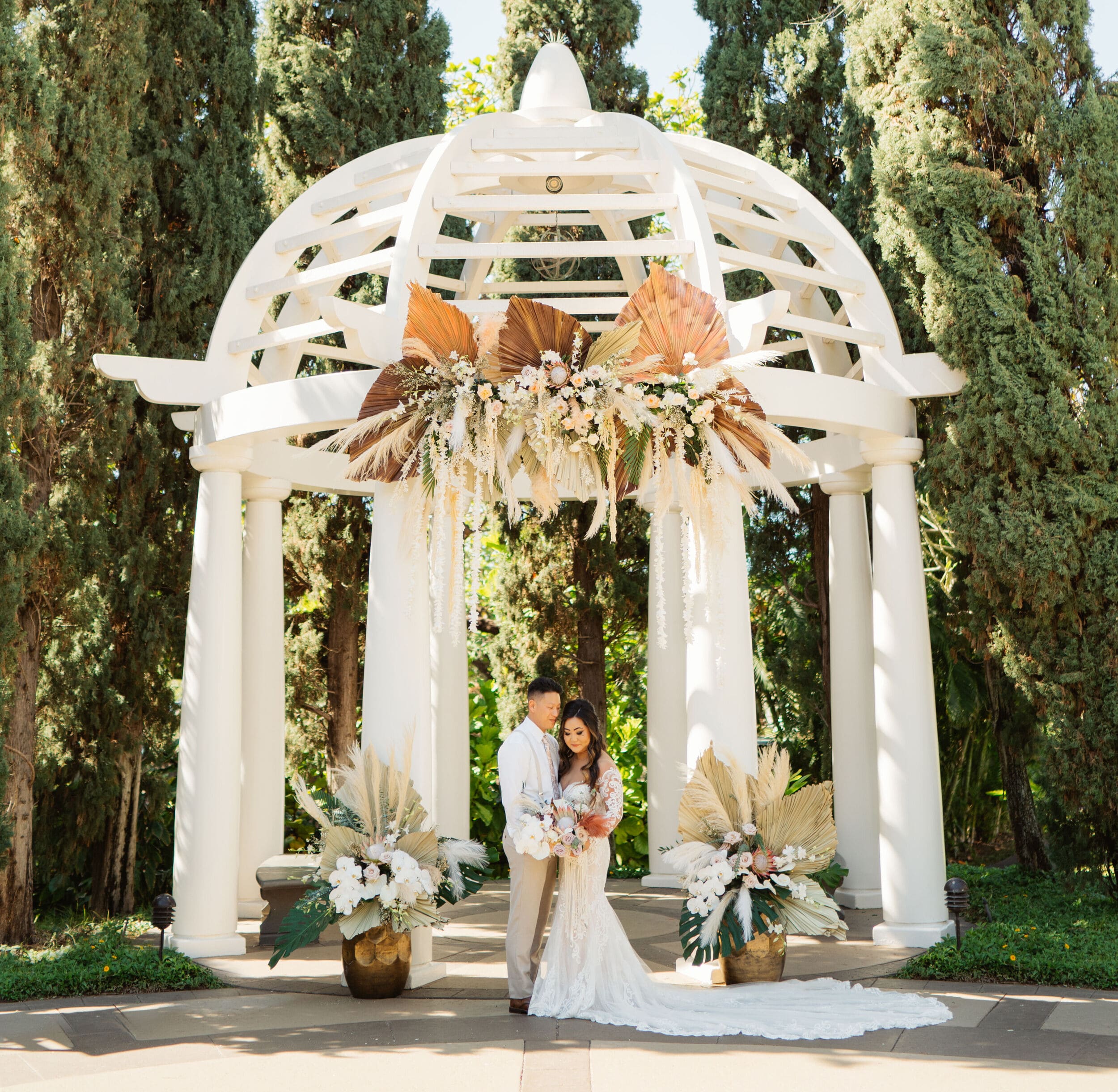bride and groom standing in front of gazebo