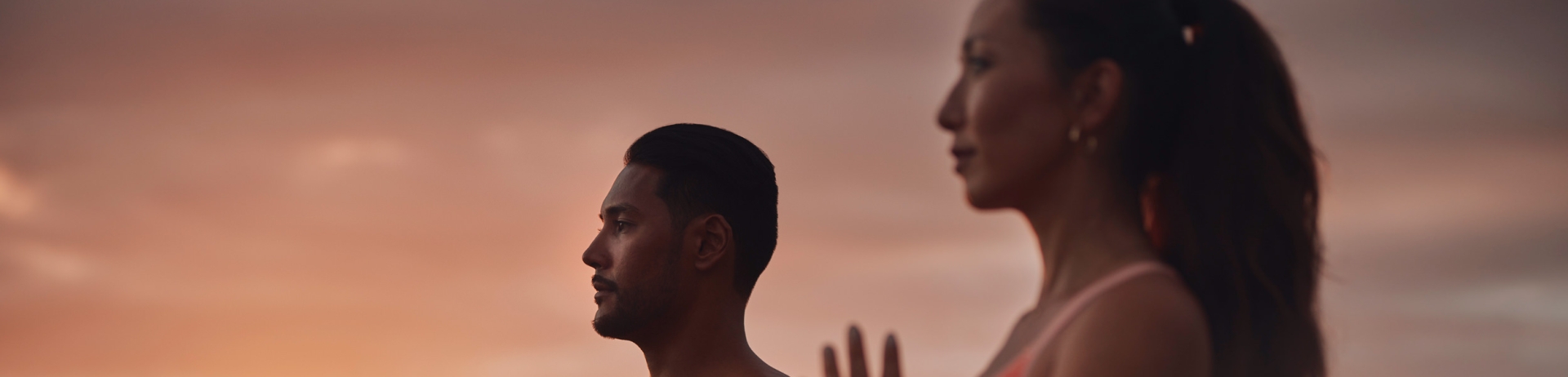two people doing yoga with the sun rise