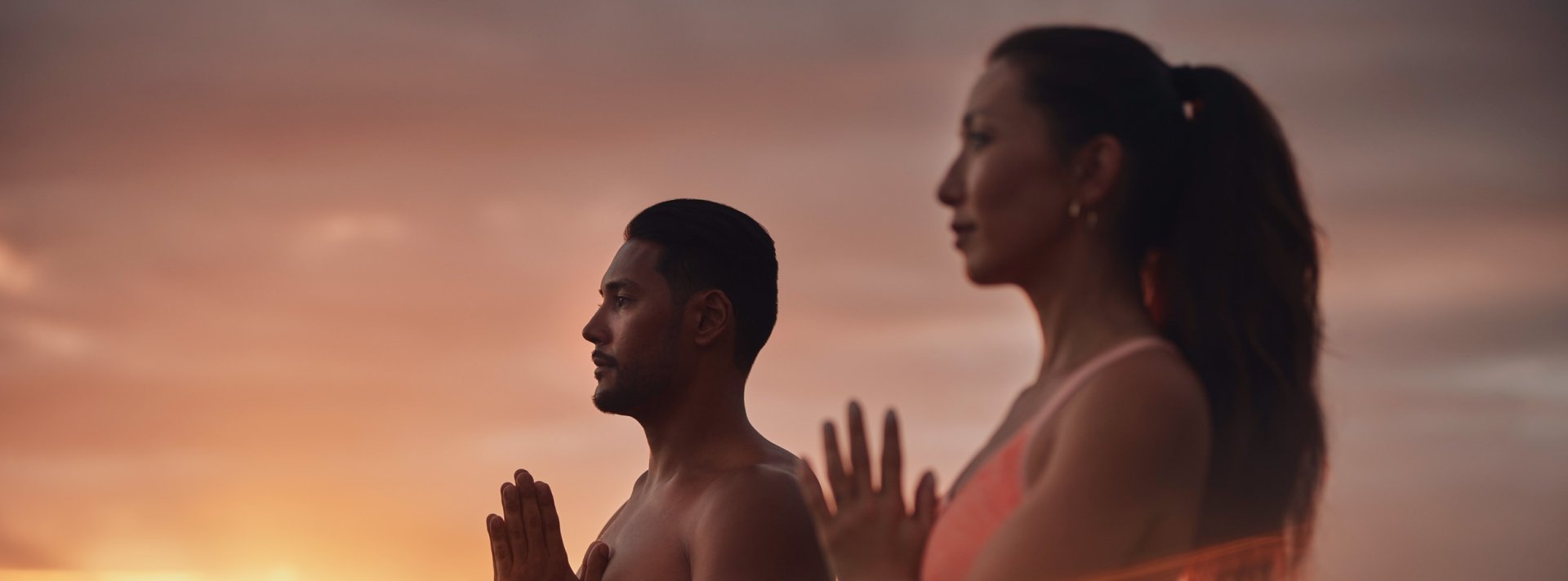 two people doing yoga with the sun rise