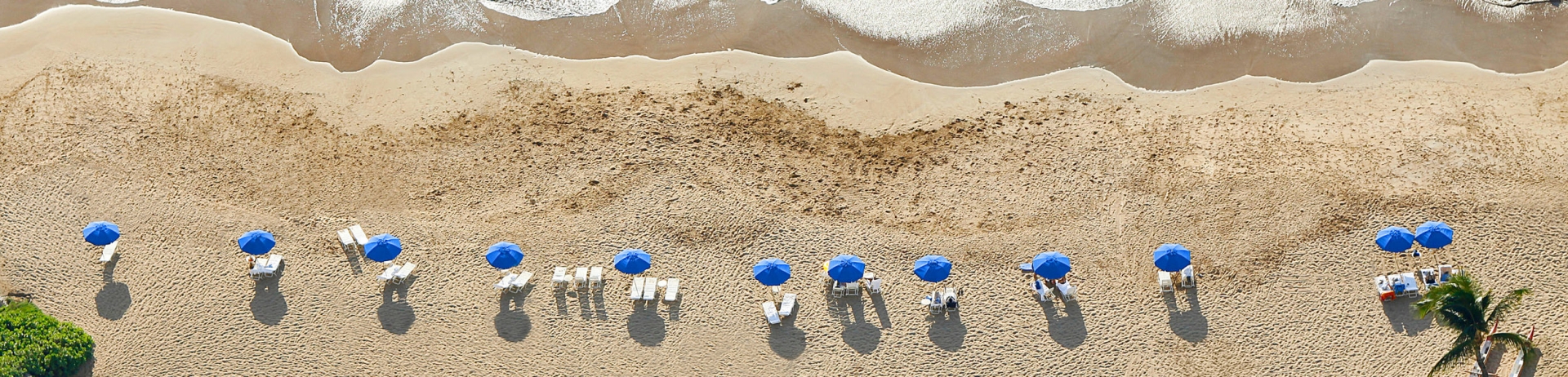 aerial of peach with lounge chairs and canoes
