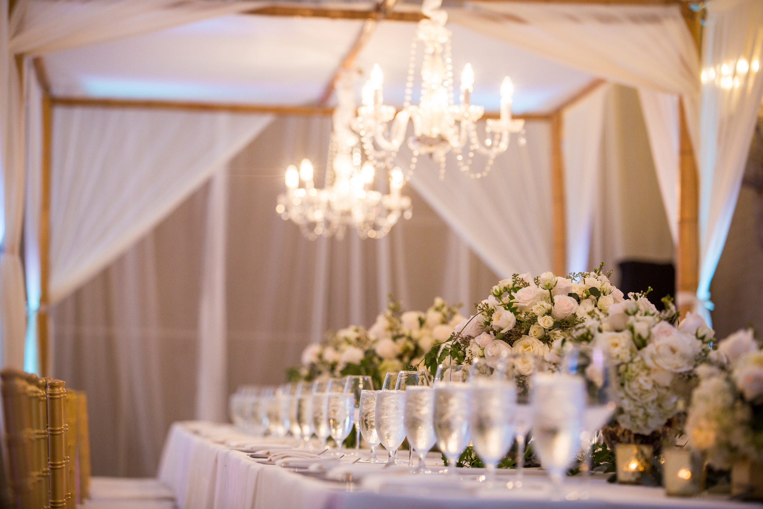 the head table at a wedding with plenty of flowers