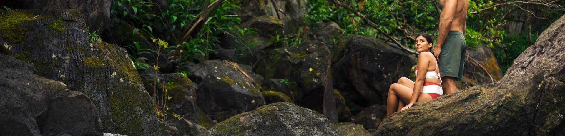 a couple sitting on rocks by the river