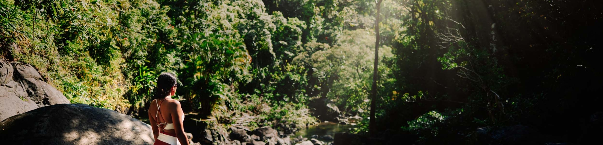 a woman on the rocks watching the river