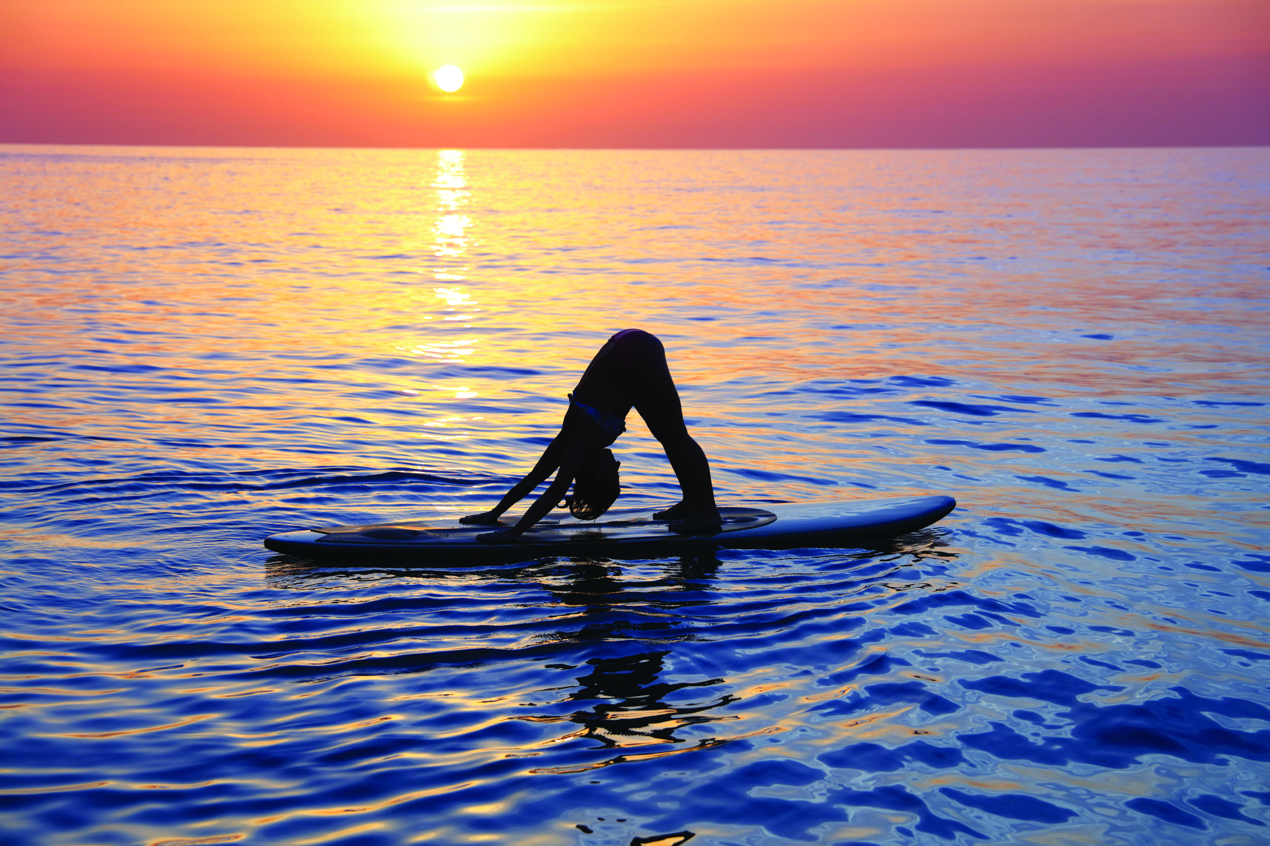 woman doing yoga on a paddleboard