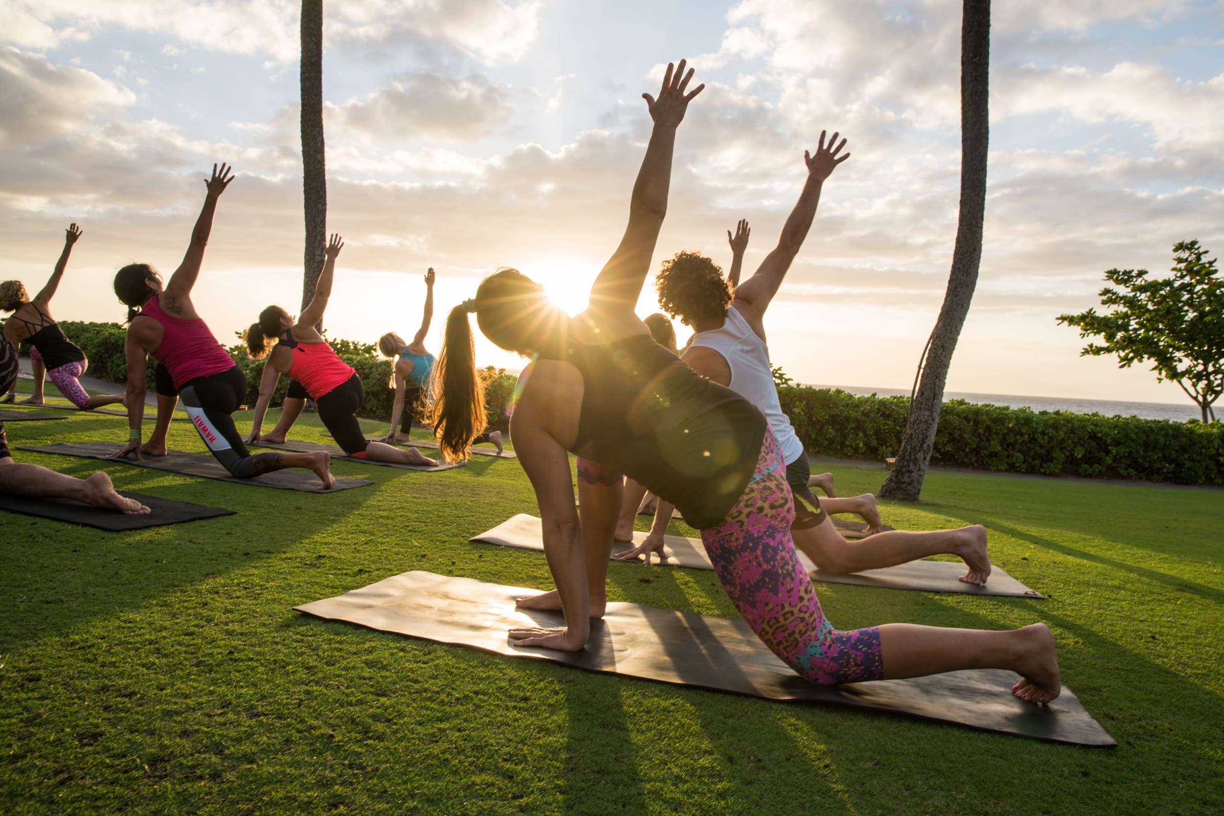 people doing yoga at sunset